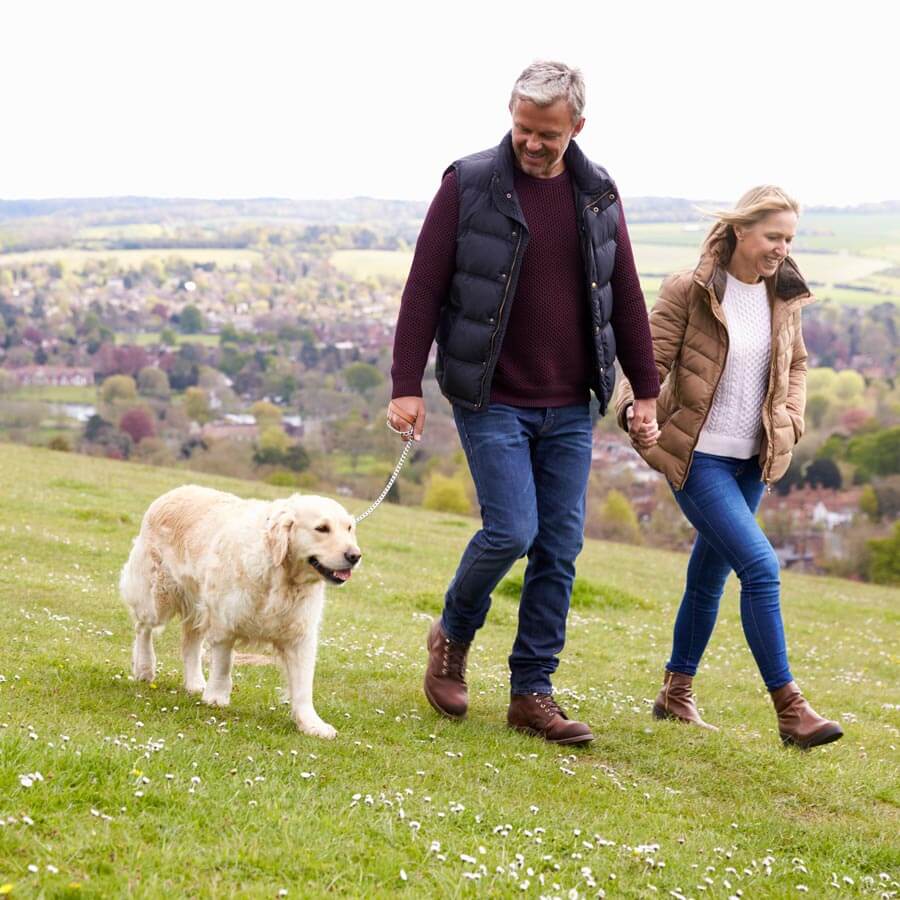 Woman and man walking dog after speaking with their boise retirement coach