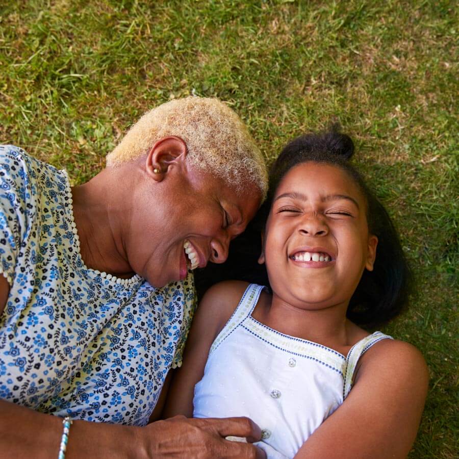 grandmother and girl lying on the grass after she spoke with her boise retirement coach